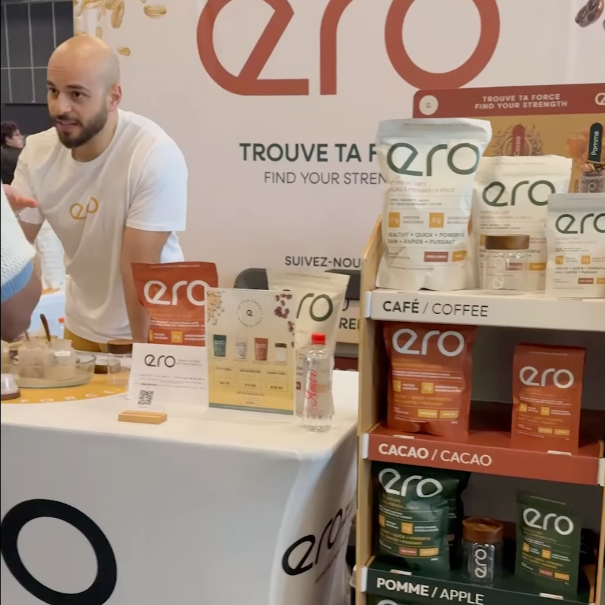 Man standing behind a table with ERO products at a live event, showcasing brand activation, product sampling, and community engagement for Ero Evergreen supplements.