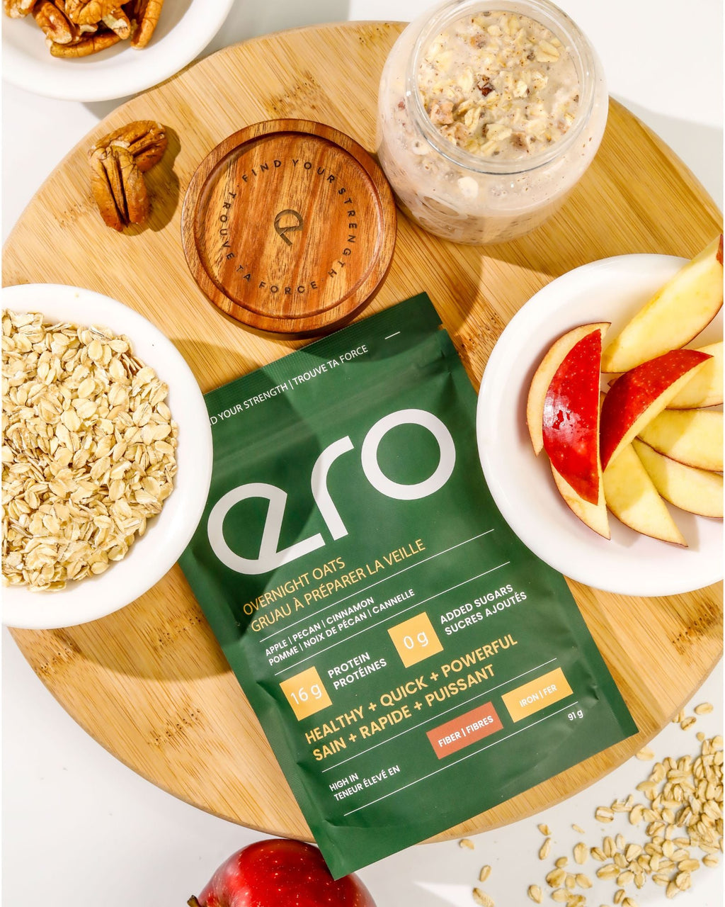 ero Apple, Pecan & Cinnamon overnight oats pouch styled with fresh apple, pecans, oats and cinnamon on a wooden board