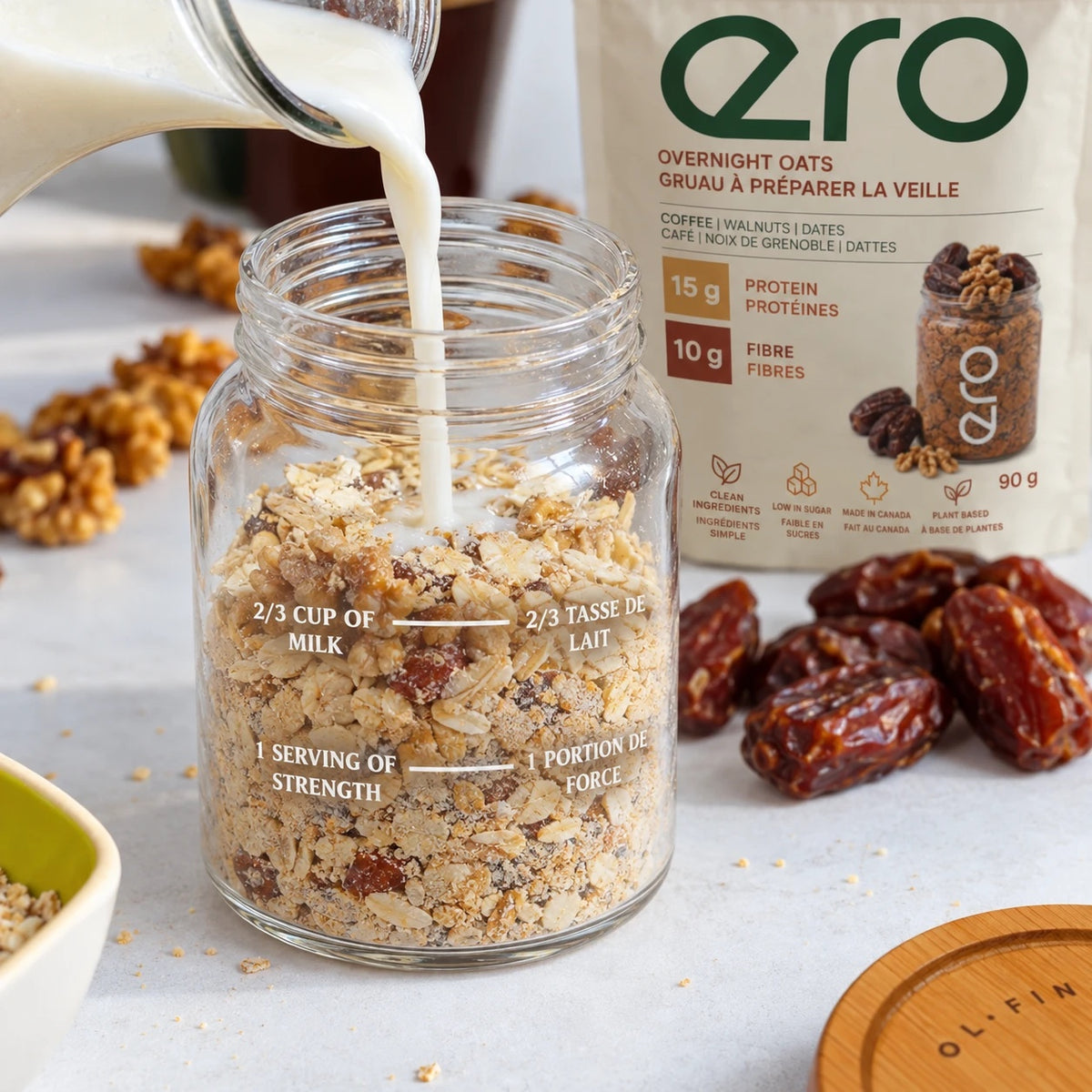 Milk poured into the ero glass jar filled with overnight oats, showing the 2/3 cup milk and one-serving measuring lines